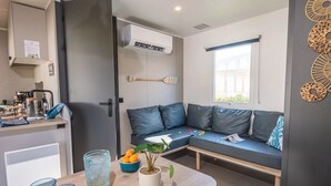 A compact living space with a kitchenette, a dining area, and a seating area with a window.