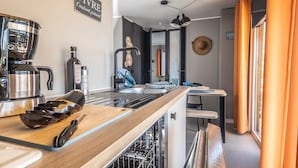 A modern kitchen with a coffee maker, a cutting board, and a sink.