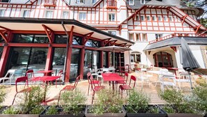 A traditional European-style building with a terrace, red and white exterior, and multiple windows. - Hôtel Miléade Les Pléïades  La Baule (La Baule-Escoublac)