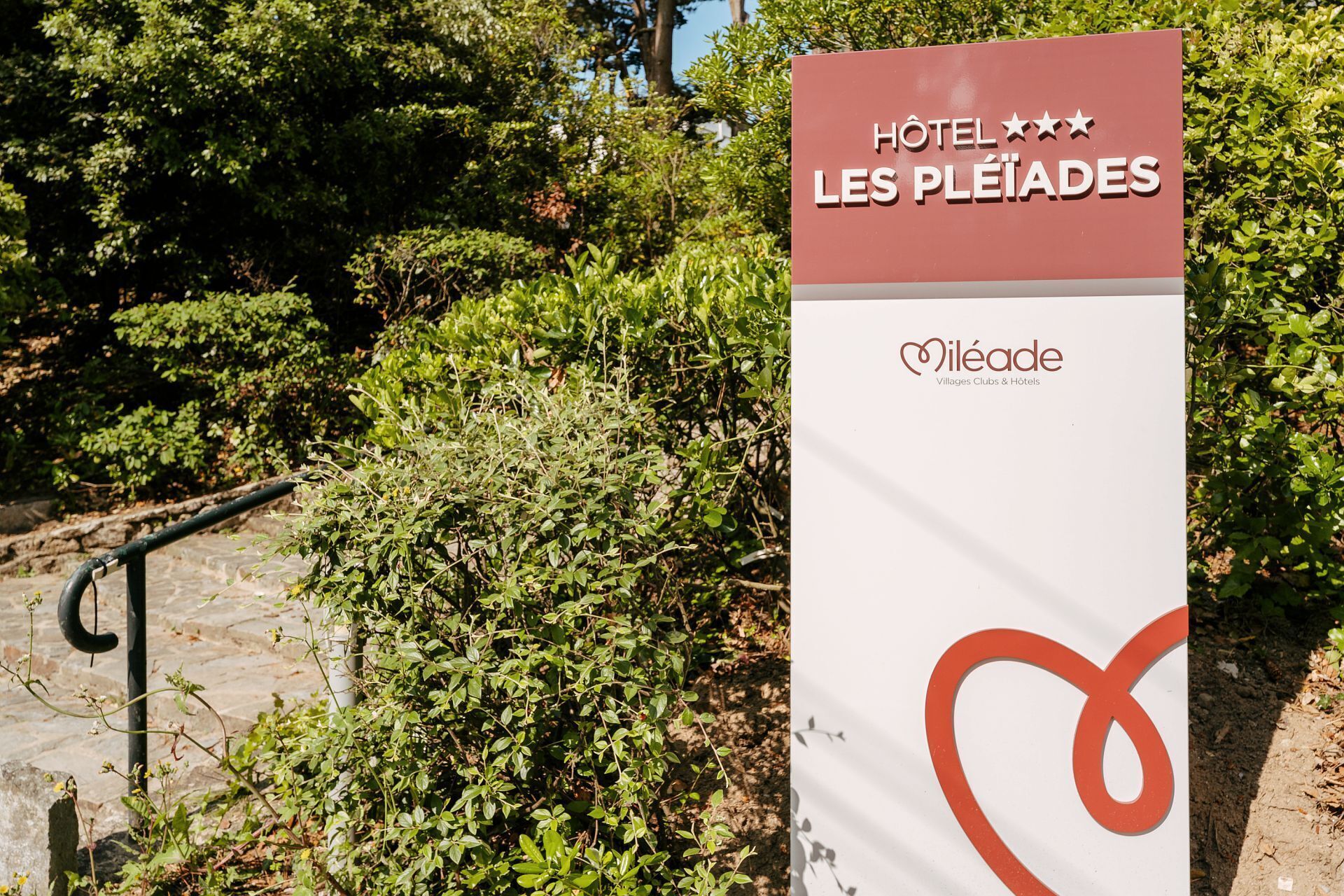 Skilt for Hotel Les Pleiades med logo og navn.