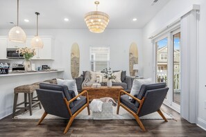 A modern living room with a grey sofa set, wooden coffee table, and wicker pendant lights.