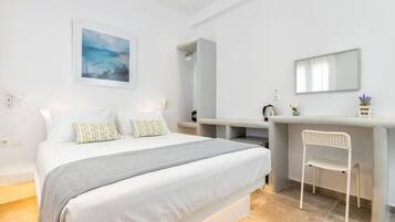 Un dormitorio moderno con cama, escritorio, silla y un ventanal grande.