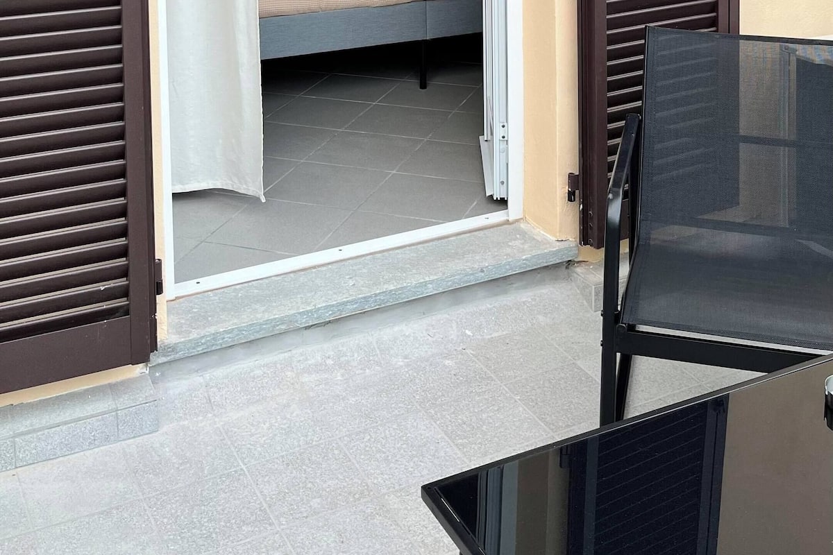 Una habitación con una cama, una silla y una mesa.