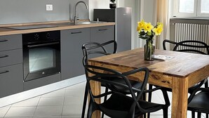 Una cocina moderna con armarios grises, una mesa de comedor de madera y sillas negras.