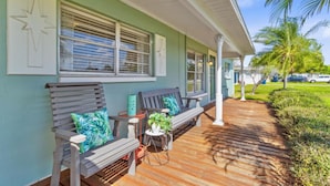 A covered porch with wooden benches and potted plants. - Perfect Location for Sports and Concert Venues! - La Cabina (Tampa)