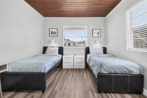 A bedroom with two beds, a window with blinds, and a view of a building outside. - Perfect Location for Sports and Concert Venues! - La Cabina (Tampa)
