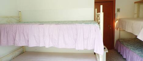 A dormitory room with two bunk beds and a single bed.