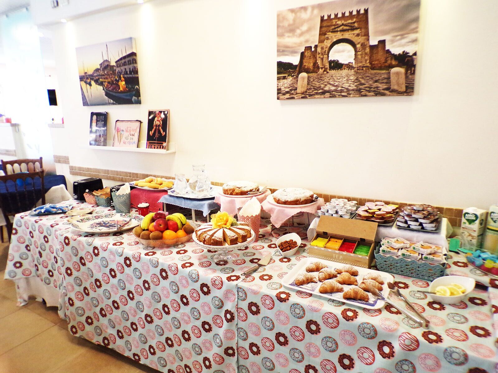 Un tavolo del buffet con diversi piatti e una parete decorata con fotografie.