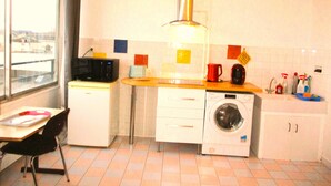 A compact kitchen with a microwave, washing machine, and a small sink. - Limoges,,belle vue ! (Limoges)