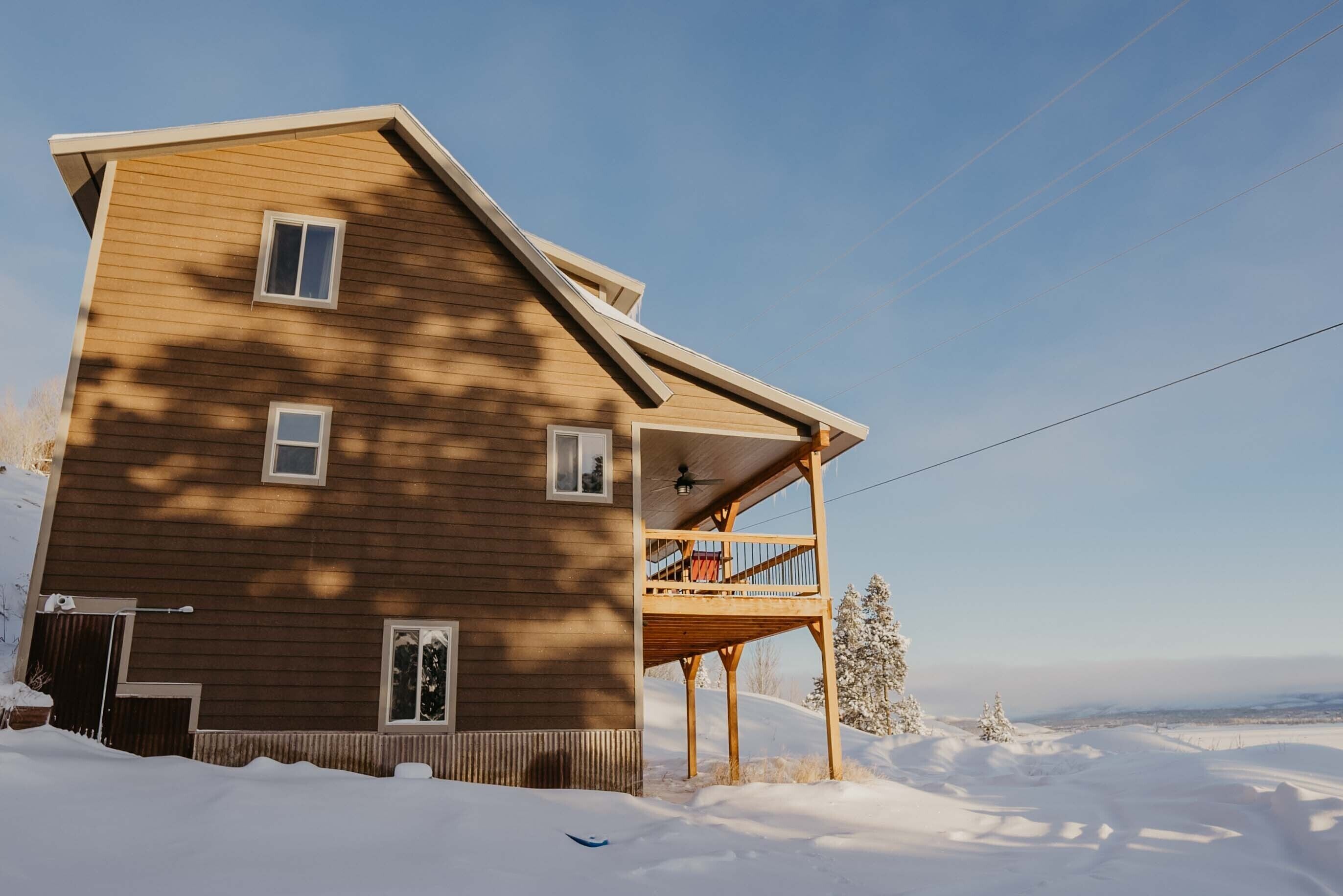 Ein zweistöckiges Holzhaus mit Balkon, umgeben von Schnee.