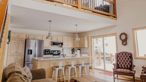 A spacious loft-style apartment with a kitchen, dining area, and a balcony. - Discover Lake Granby steps away (Granby)