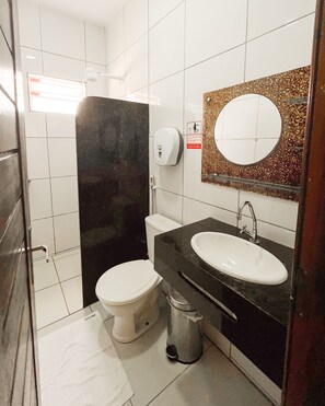 A bathroom with a toilet, sink, and a hand dryer. - Pousada do Rancho (Barreirinhas)