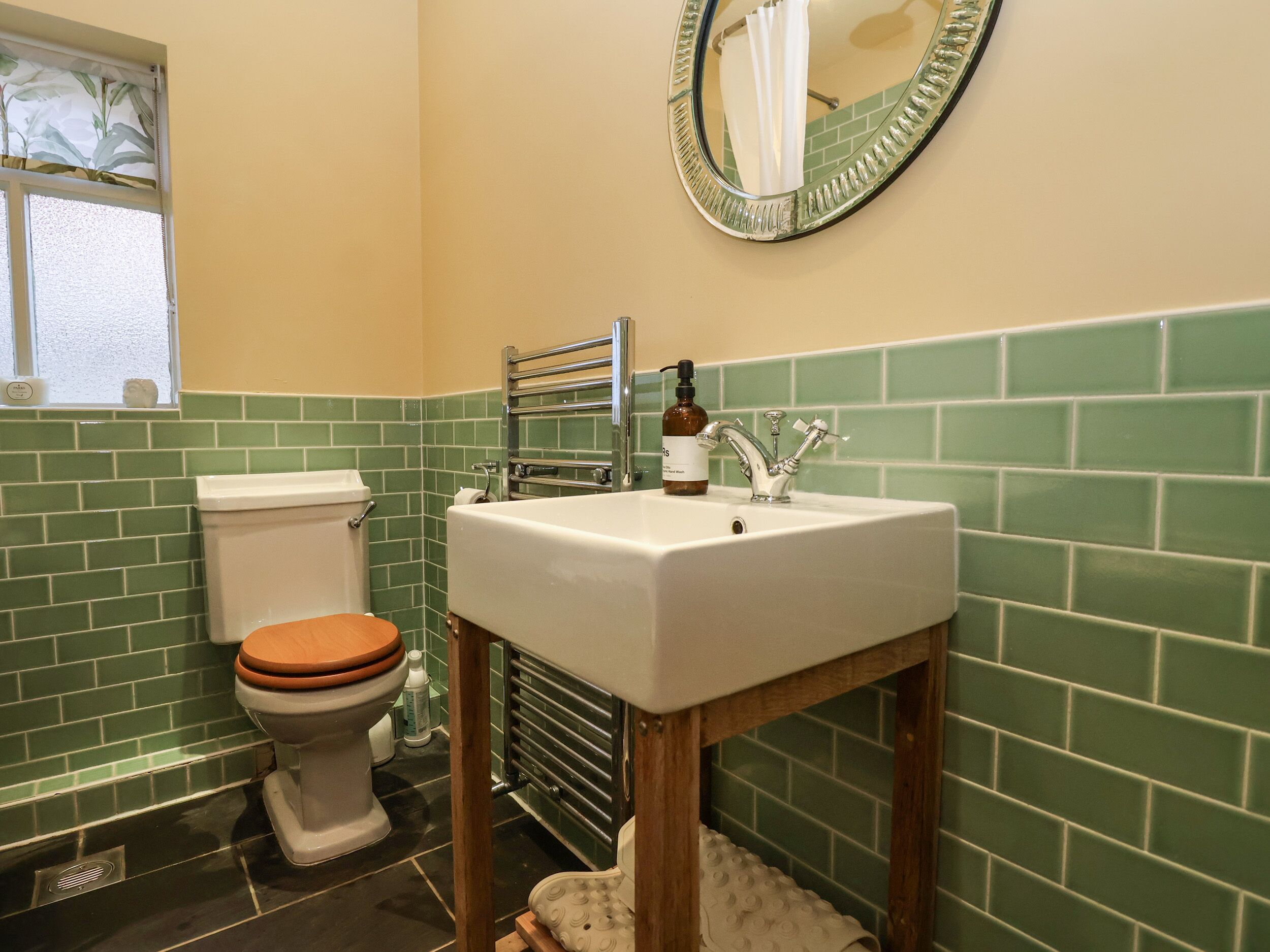 A bathroom with a toilet, sink, and mirror.