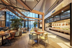 A modern restaurant with high ceilings, large windows, and a variety of seating options. - Aloft Beijing Huairou (Huairou)