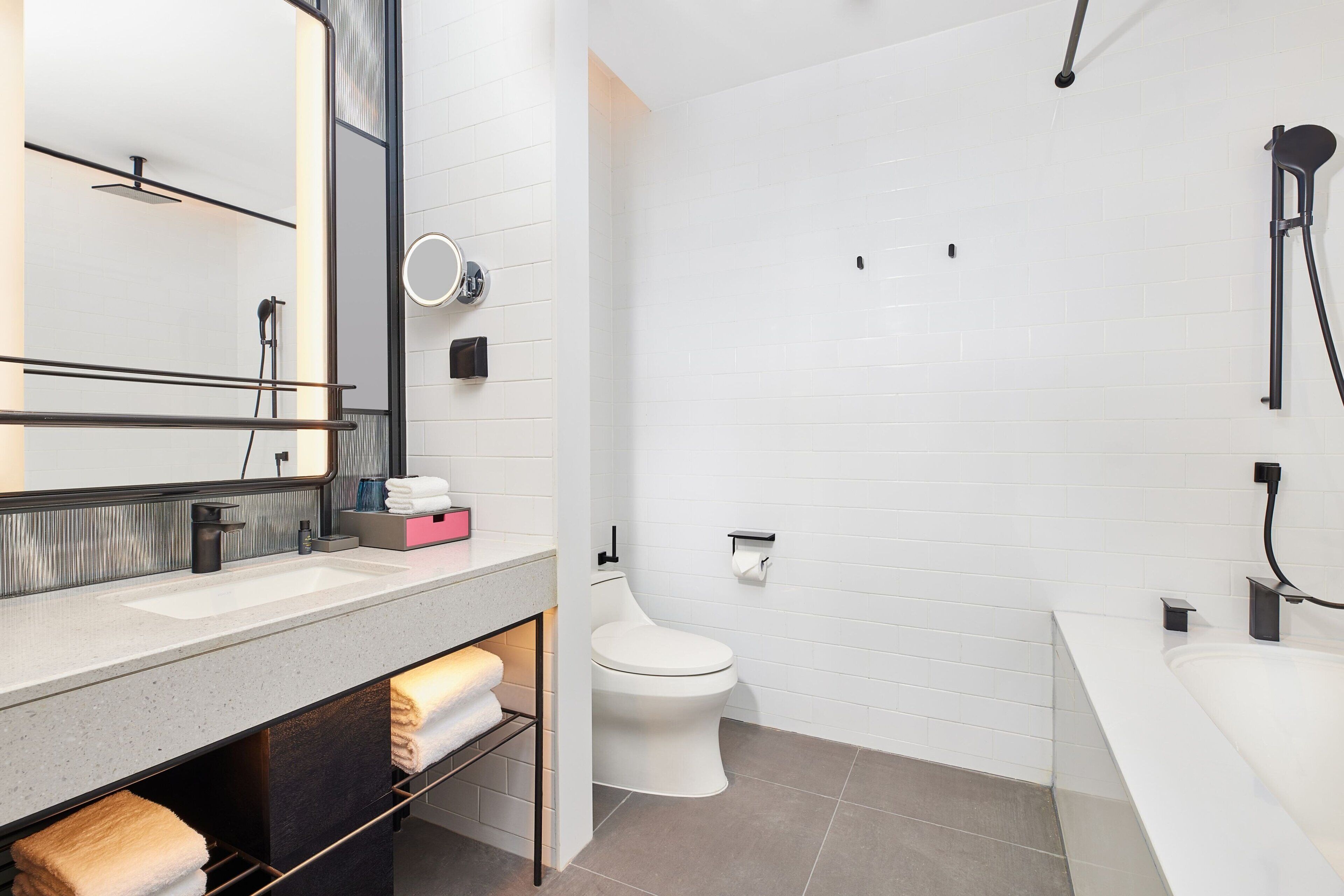 A modern bathroom with a white sink, a toilet, and a bathtub.