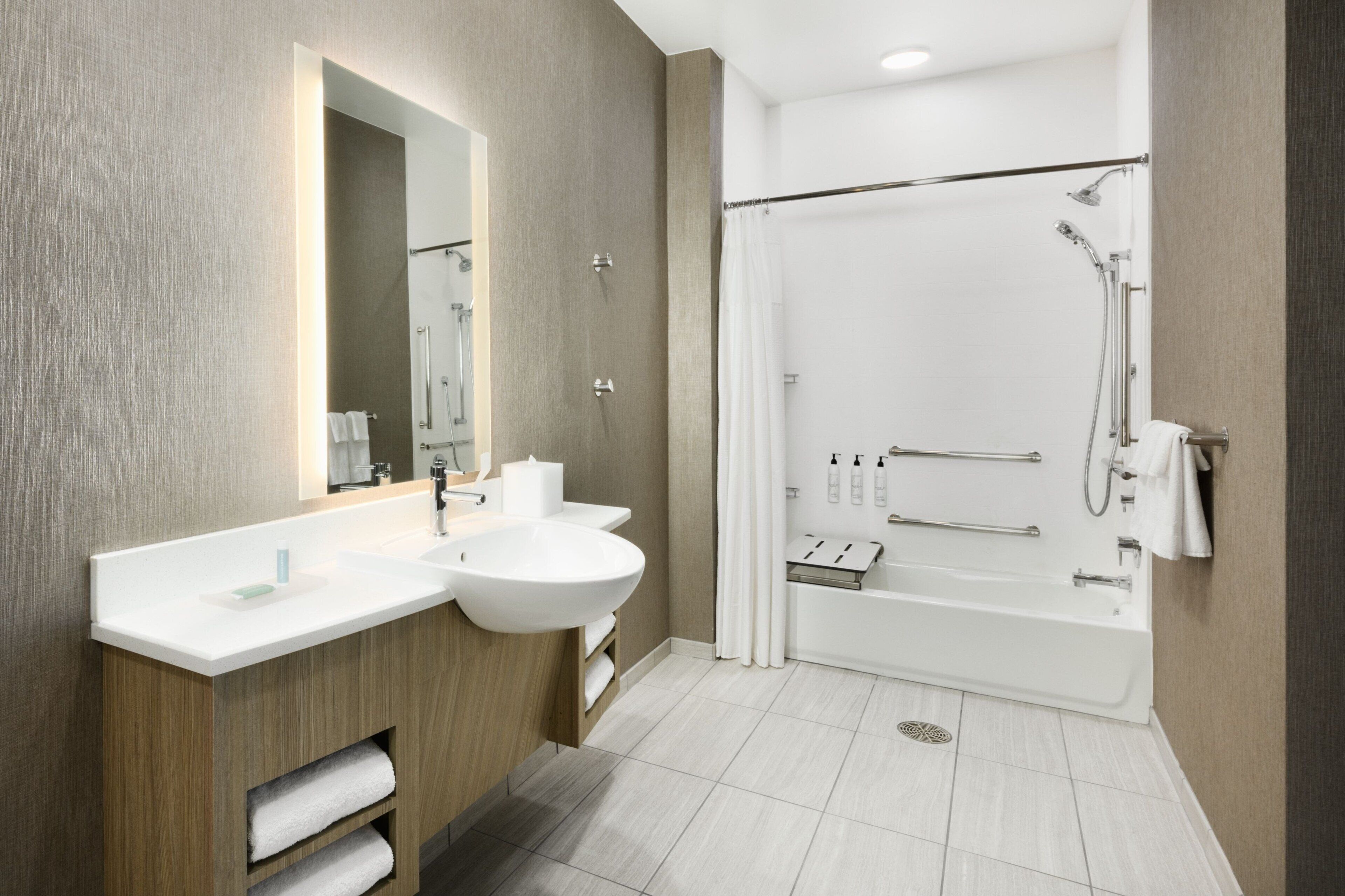 Une salle de bain moderne dotée d’un meuble-lavabo à deux vasques, d’un grand miroir, d’une douche à l’italienne et d’une baignoire.