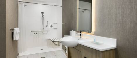 Un baño moderno con ducha, lavabo y espejo.