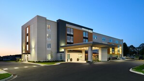 Un hôtel moderne doté d’un toit plat, de grandes fenêtres et d’une entrée bien éclairée.