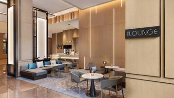 Un área de lounge moderna con disposición de asientos, un bar y un cartel que indica 'THE LOUNGE'.