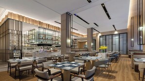 Un restaurant moderne avec des tables et des chaises hautes, un coin bar et une grande fenêtre.