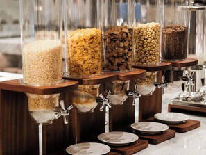 A cereal dispenser with multiple containers of different cereals. - Courtyard By Marriott Shanwei Haifeng (Shanwei)
