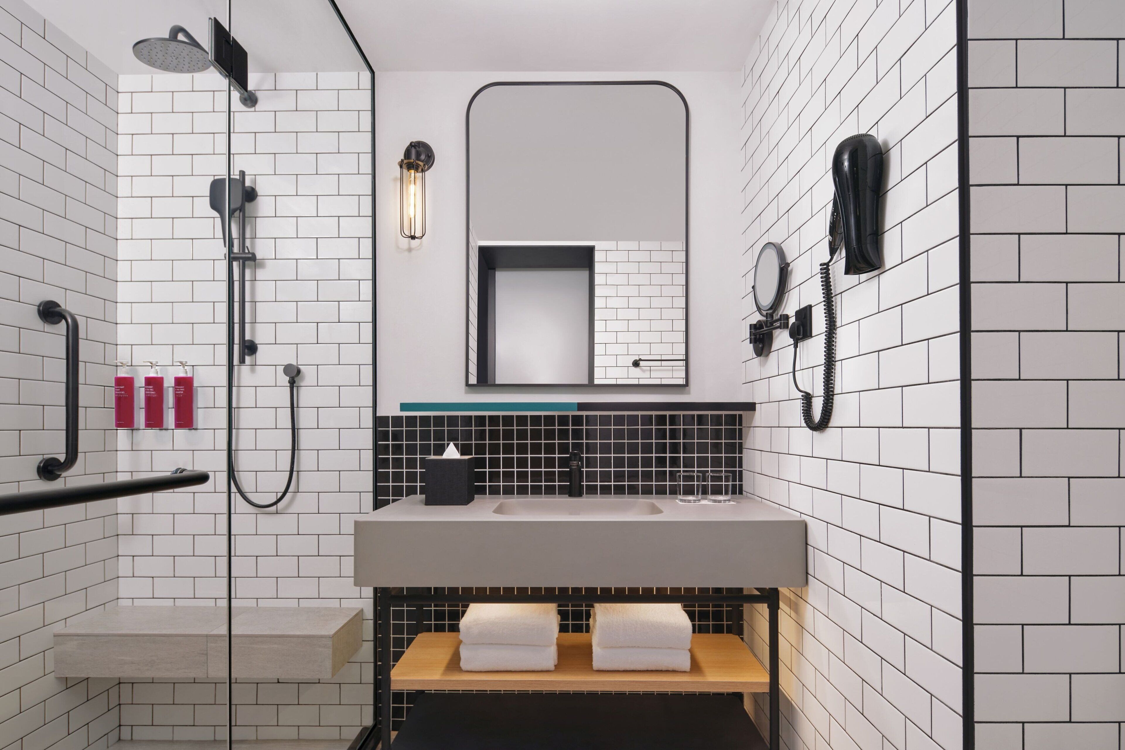 A modern bathroom with a shower, a sink, and a mirror.