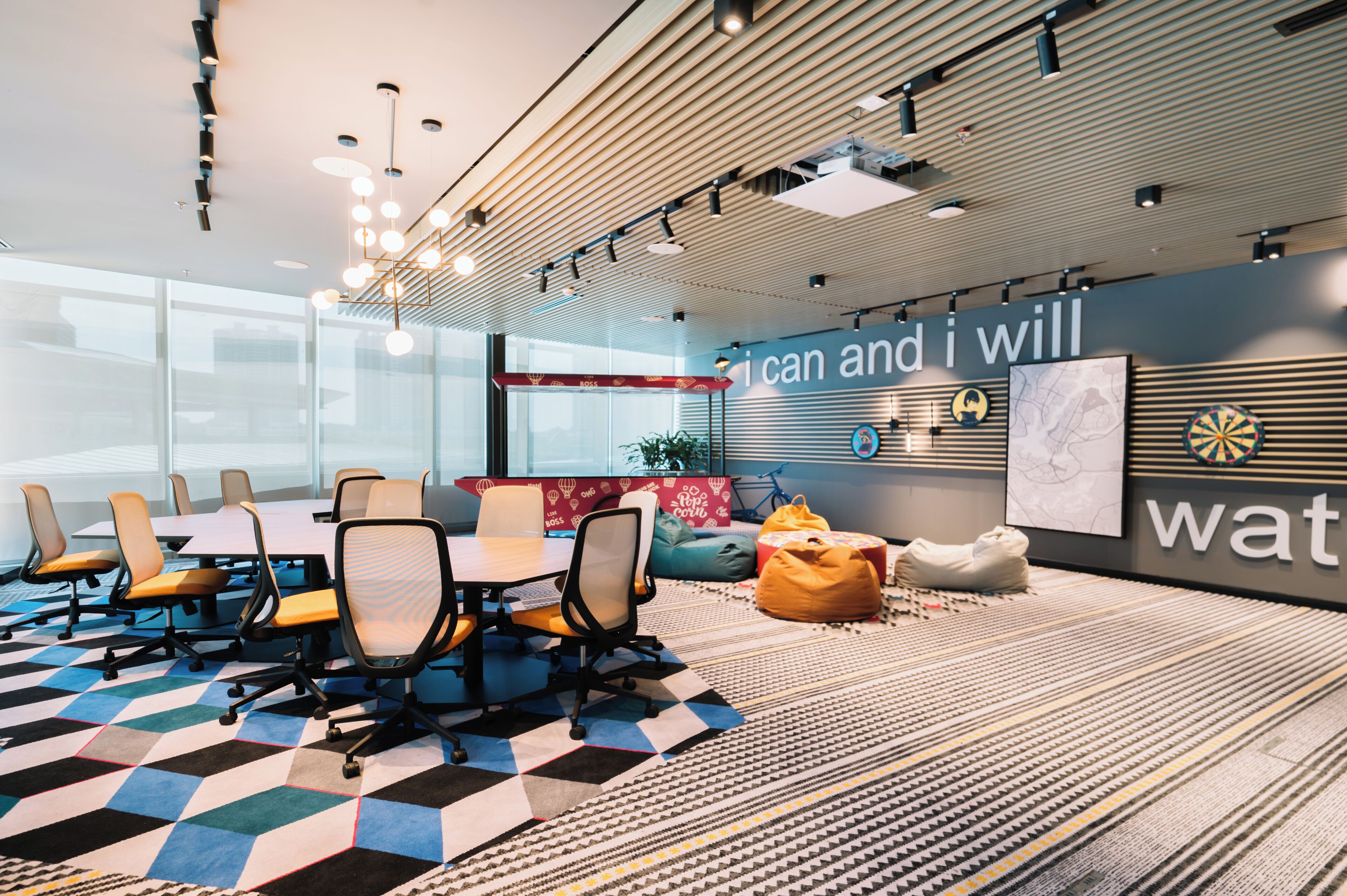 A modern conference room with a large table, chairs, and a motivational wall.