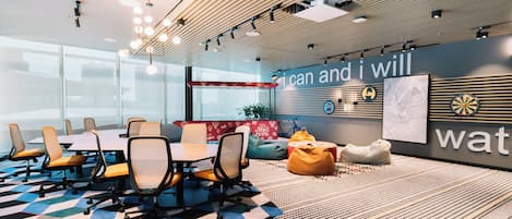 A modern conference room with a large table, chairs, and a motivational wall.
