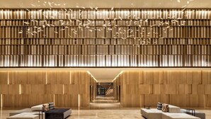 A modern hotel lobby with a central seating area, a wooden panel wall, and a long corridor leading to the entrance. - JW Marriott Hotel Nairobi (Nairobi)