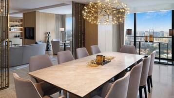Uma sala de jantar moderna com uma mesa de mármore, seis cadeiras e um lustre decorativo.