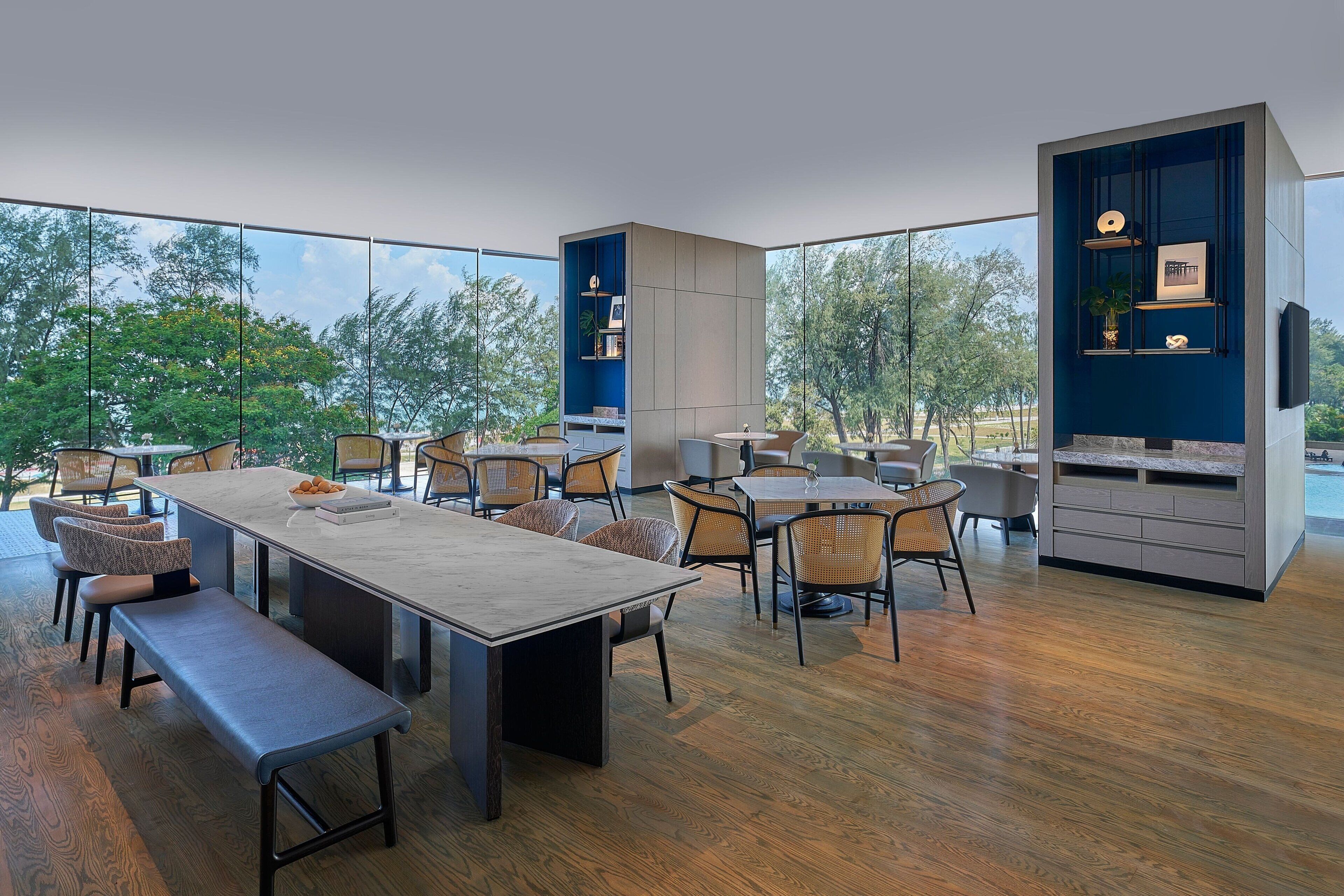 A modern dining area with a long table, multiple chairs, and built-in shelving units.