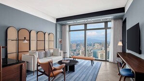 A modern hotel room with a city view, a sofa, a coffee table, a desk, and a TV. - Le Méridien Shenzhen, Bao'An (Shenzhen)