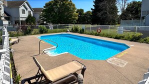 A swimming pool with lounge chairs and a fenced area. - 2 bedroom townhome with view of the mountain (Collingwood)