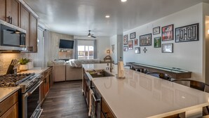 A modern kitchen with a central island, built-in oven, and a dining area with a sofa. - Modern Vista Vibes: Your Epic Red River Escape (Red River)