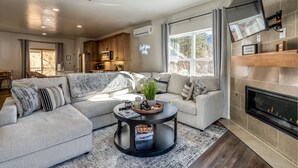 A modern living room with a sectional sofa, a round coffee table, and a fireplace. - Modern Vista Vibes: Your Epic Red River Escape (Red River)
