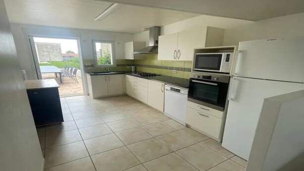 A kitchen with white cabinets, a microwave, an oven, and a dishwasher. - House 10/12pers town center 5mn from Puy Du Fou "AU COEUR DU BOURG (Chanverrie)