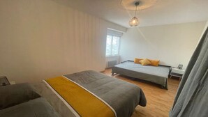 A bedroom with two beds, a window, and a ceiling light fixture. - House 10/12pers town center 5mn from Puy Du Fou "AU COEUR DU BOURG (Chanverrie)