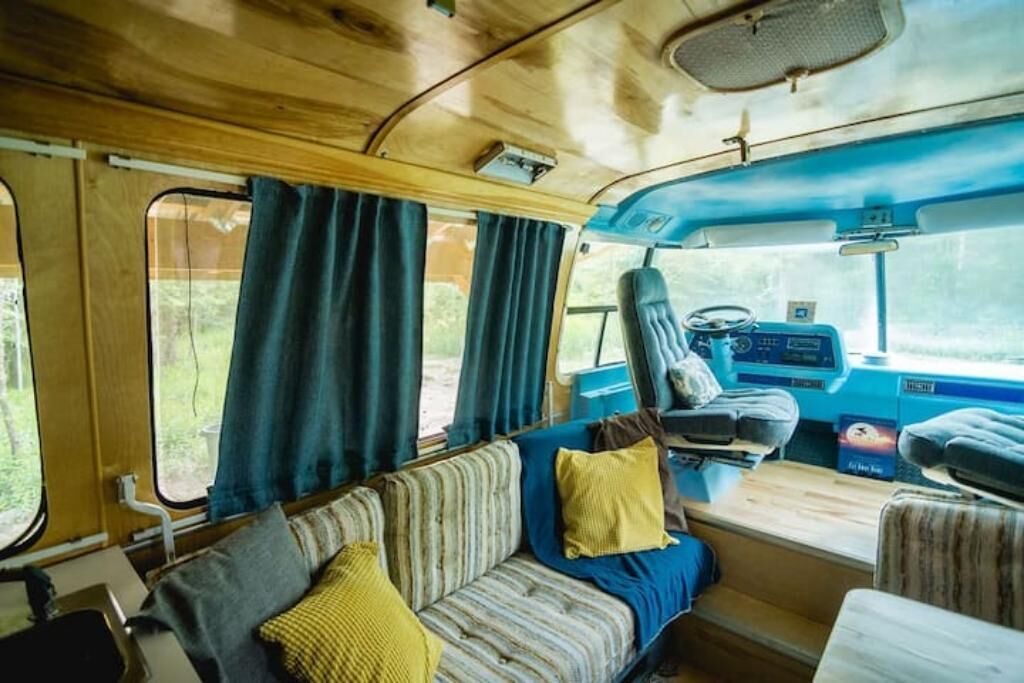 Un interior acogedor con un sofá a rayas, una mesita y cortinas.