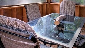 A wooden cabin interior with a glass table, patterned chairs, and a view of a forest through large windows. - Unique Glamping RV on 100 acres 1 hr from Toronto (Blackstock)