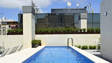 Een buitenzwembad en ligstoelen