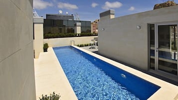 Een buitenzwembad en ligstoelen