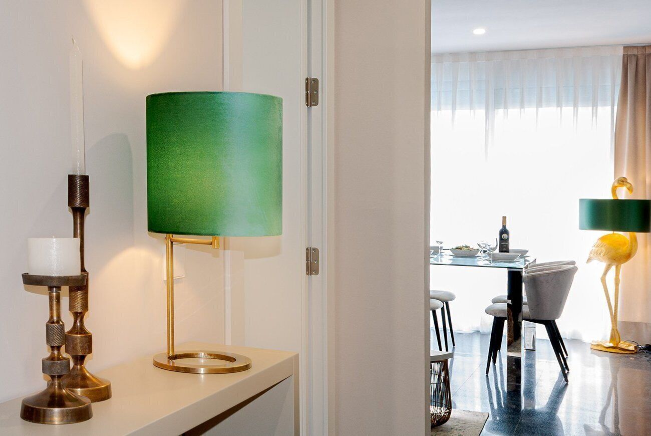 Une chambre d’hôtel moderne avec un coin repas visible à travers une porte ouverte.