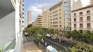 Una calle urbana con edificios modernos, una parada de autobús y cielo despejado.