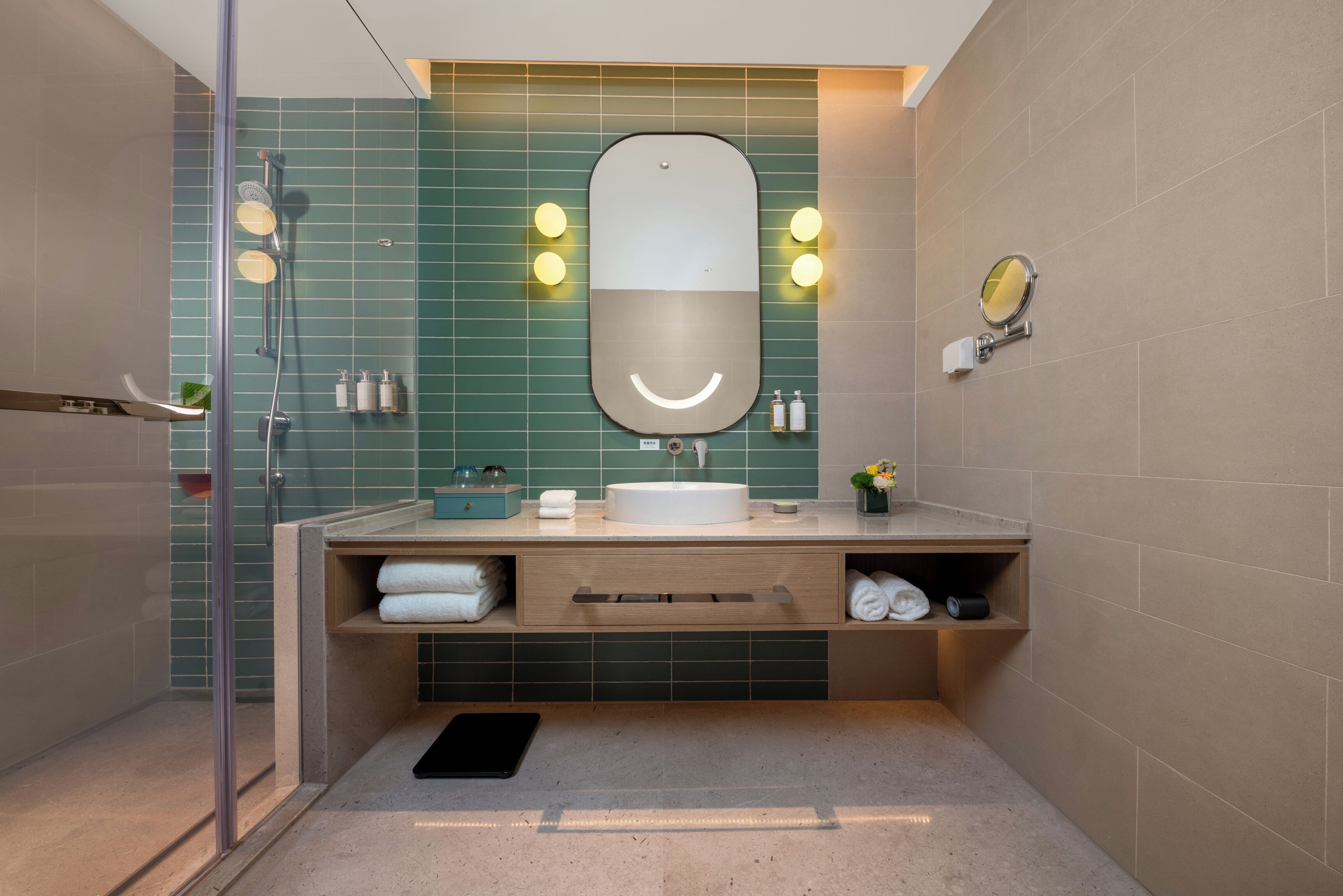 Un baño moderno con cabina de ducha de vidrio, tocador con espejo y lavabo.