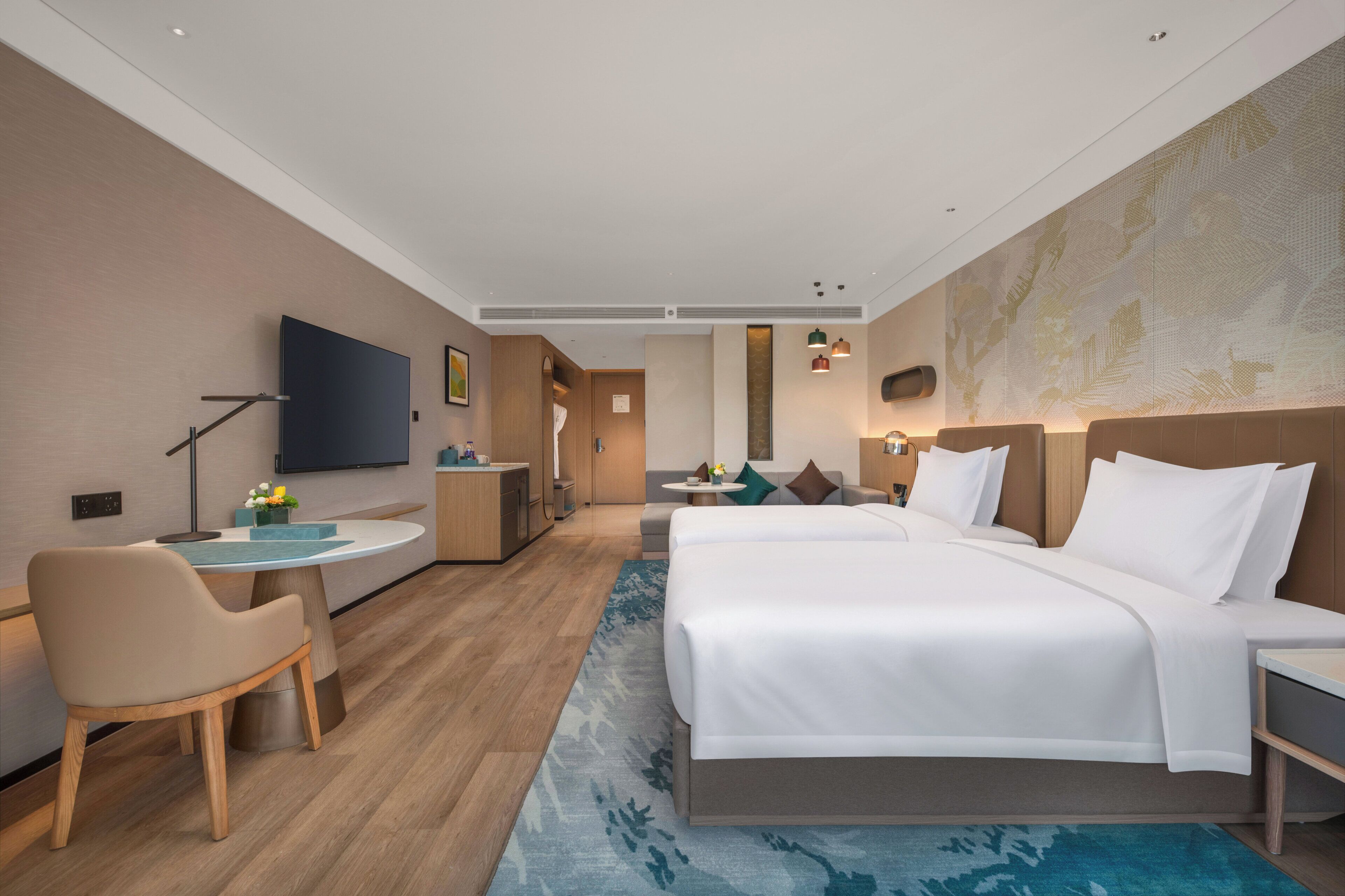 Una habitación de hotel moderna con una cama grande, un escritorio, una silla y un televisor.