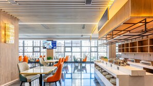 A modern dining area with tables and chairs, a buffet counter, and large windows offering views of the city. - Holiday Inn Express Xi An Guangyuntan by IHG (Xi'an)