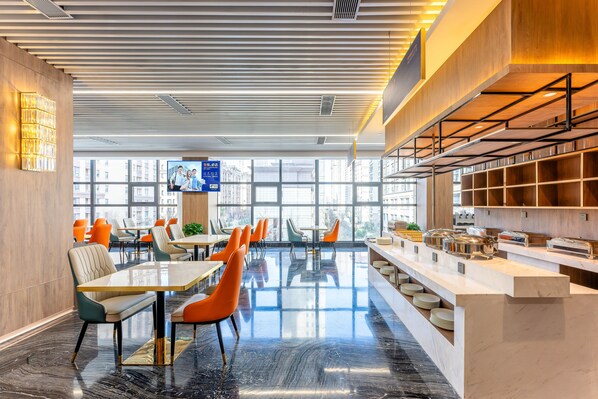A modern dining area with tables and chairs, a buffet counter, and large windows offering views of the city. - Holiday Inn Express Xi An Guangyuntan by IHG (Xi'an)