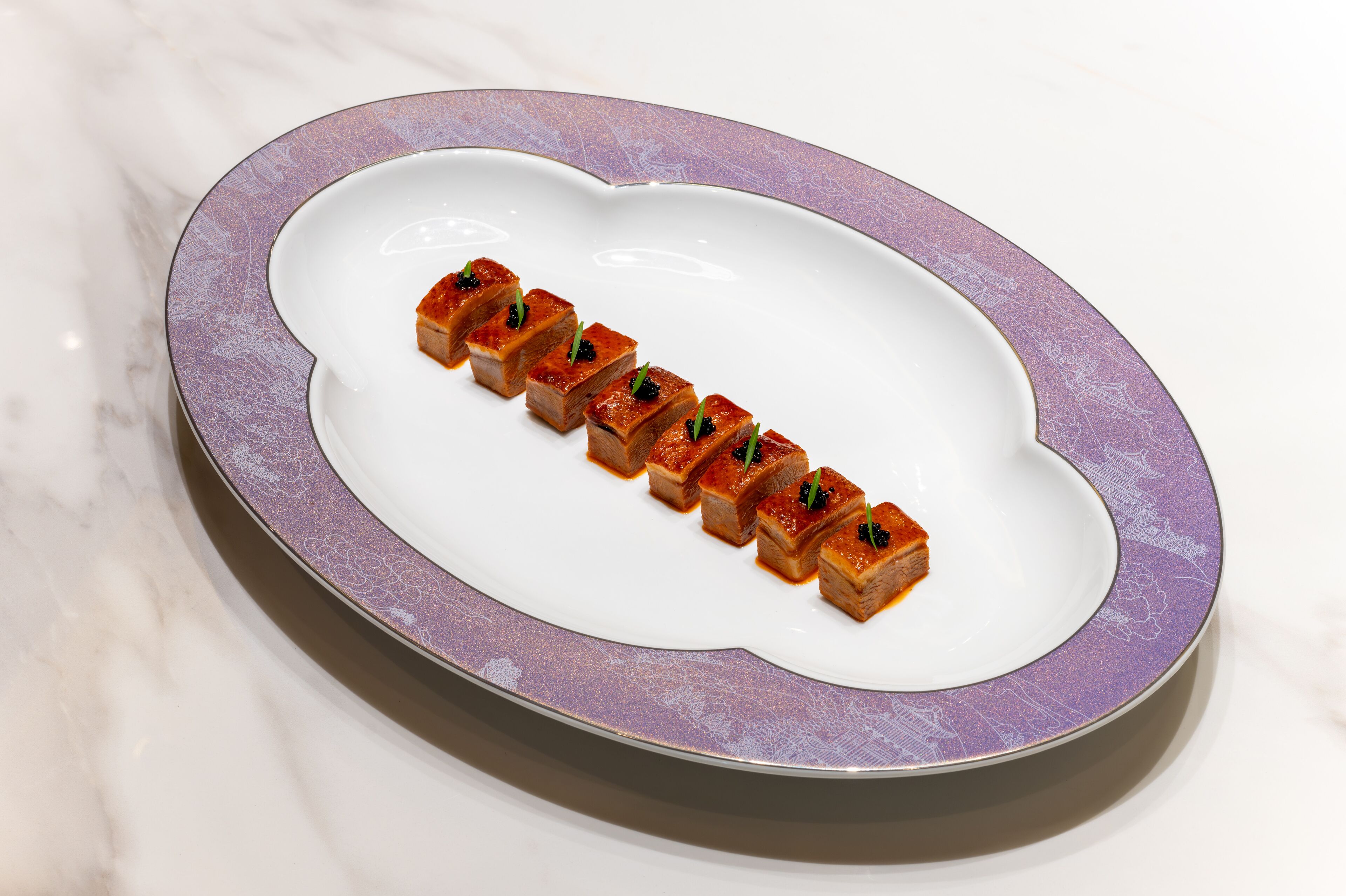 A white plate with a purple rim on a marble surface.