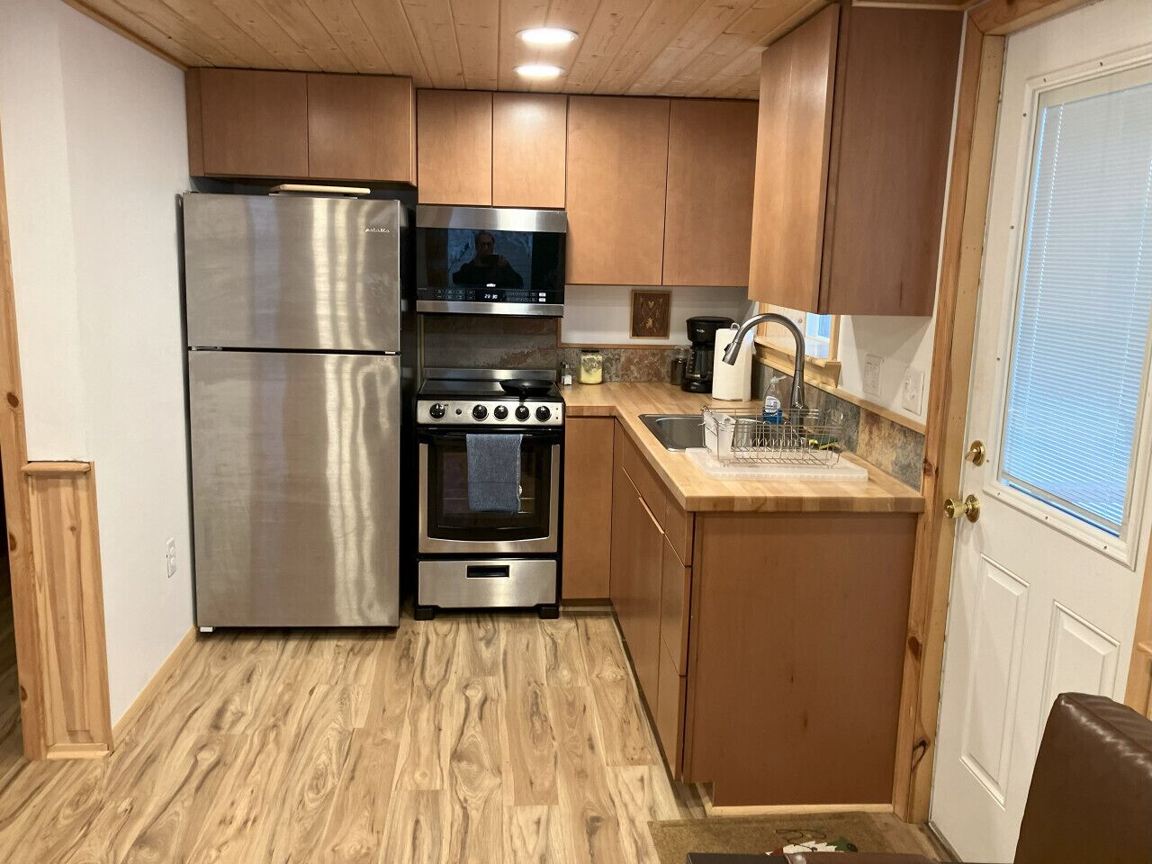 A compact kitchen with a refrigerator, oven, and microwave.
