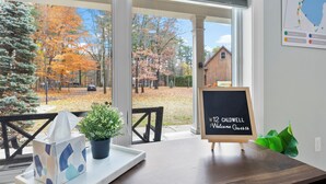 A wooden table with a tissue box, a potted plant, and a chalkboard sign. - Luxurious Lake George Getaway (Lake George)
